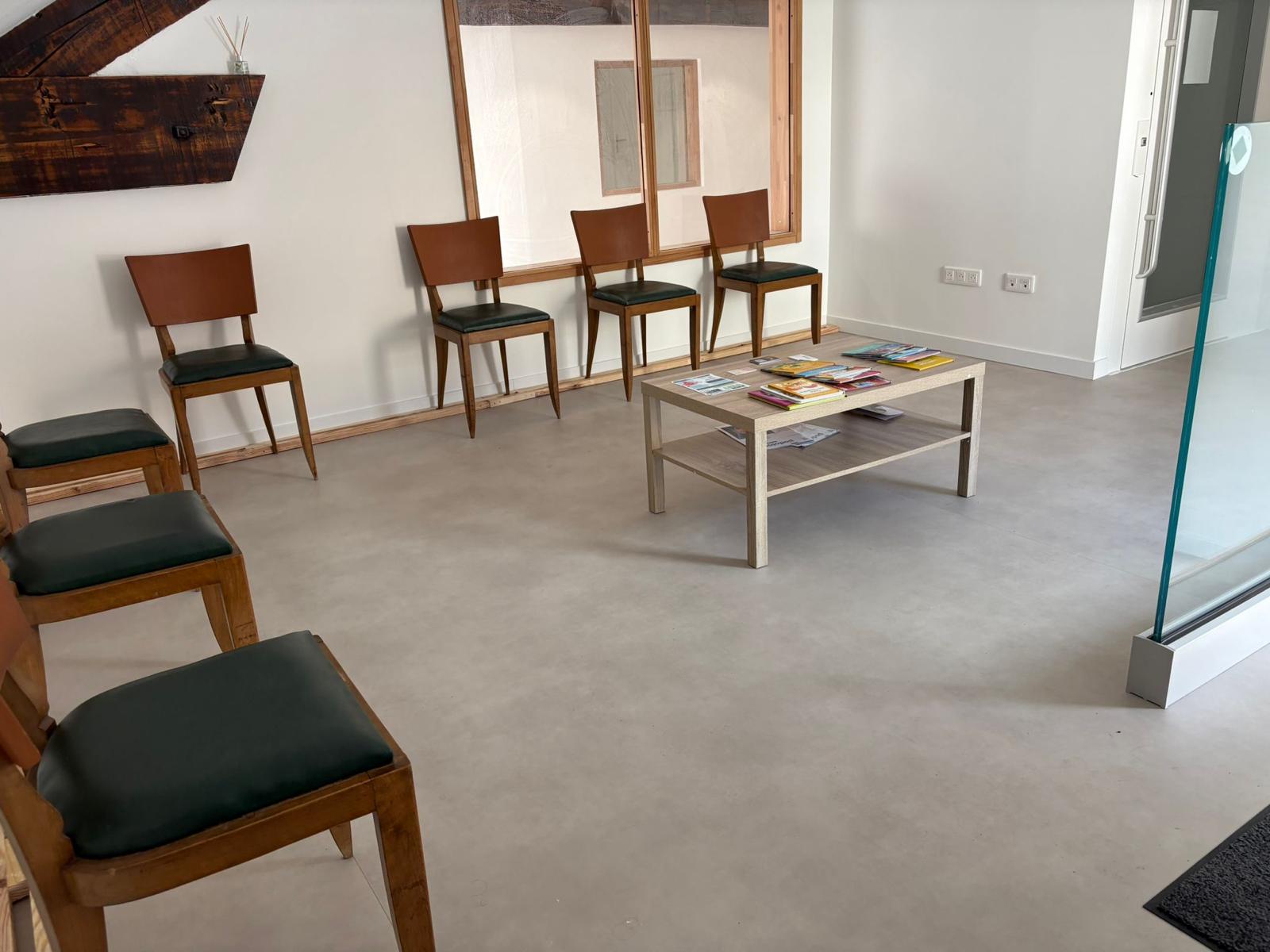 Salle d'attente avec fauteuils en bois et poutres apparentes